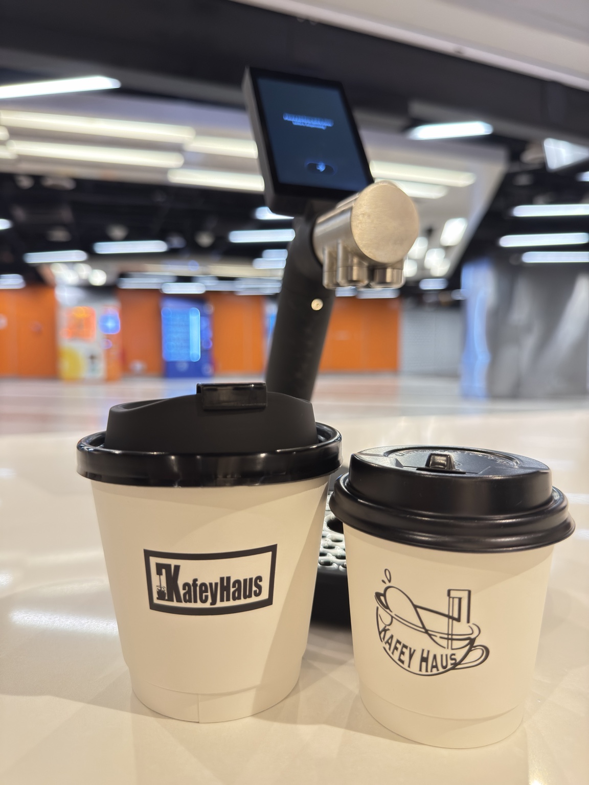 Whitextar ONEPRESS machine with two branded Kafey Haus takeaway cups